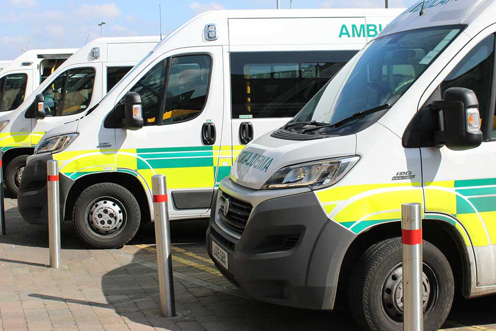 A row of patient transport ambulances outside Queen's Hospital